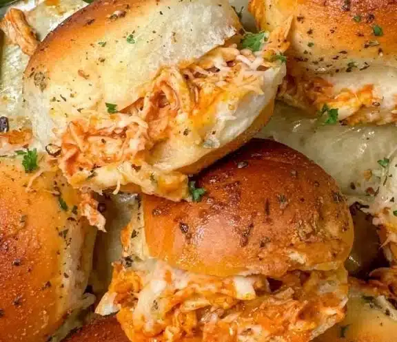 Spicy buffalo chicken sliders served on a platter with dipping sauce