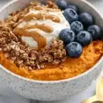 Delicious sweet potato breakfast bowl topped with fruits and nuts