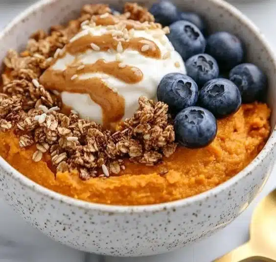 Delicious sweet potato breakfast bowl topped with fruits and nuts