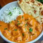 Delicious plate of butter chicken served with rice and naan