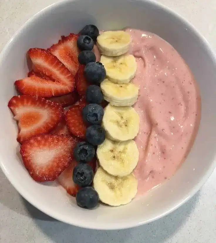 5-minute strawberry banana smoothie bowl topped with fresh fruit and granola