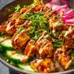 Delicious Bang Bang Chicken Bowl topped with fresh ingredients and spicy sauce.