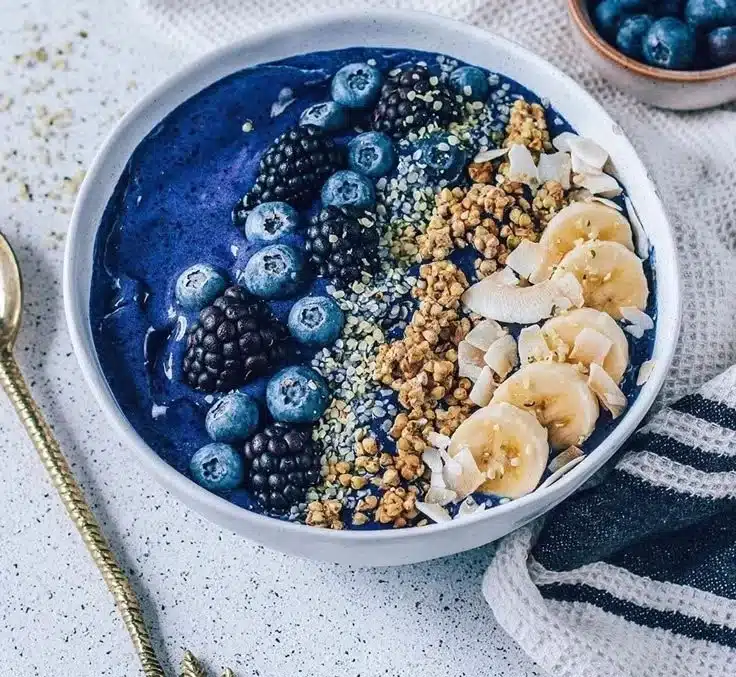 A vibrant berry smoothie bowl topped with fresh fruits and granola