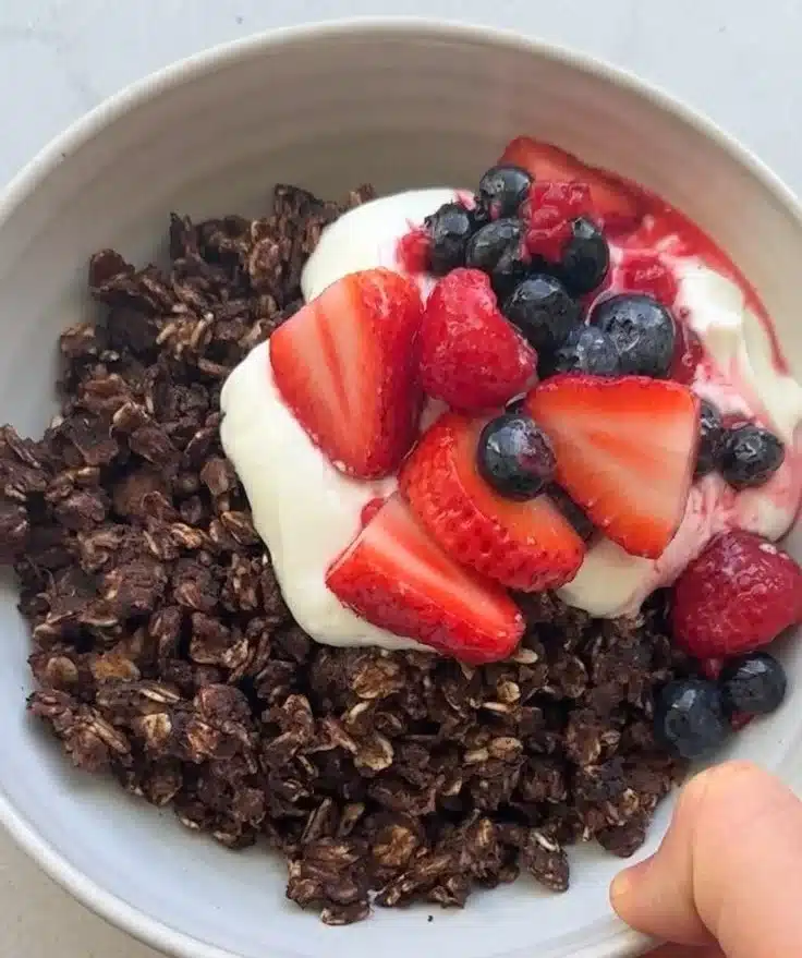 Bowl of Chocolate Scrambled Oats topped with fresh fruits and nuts