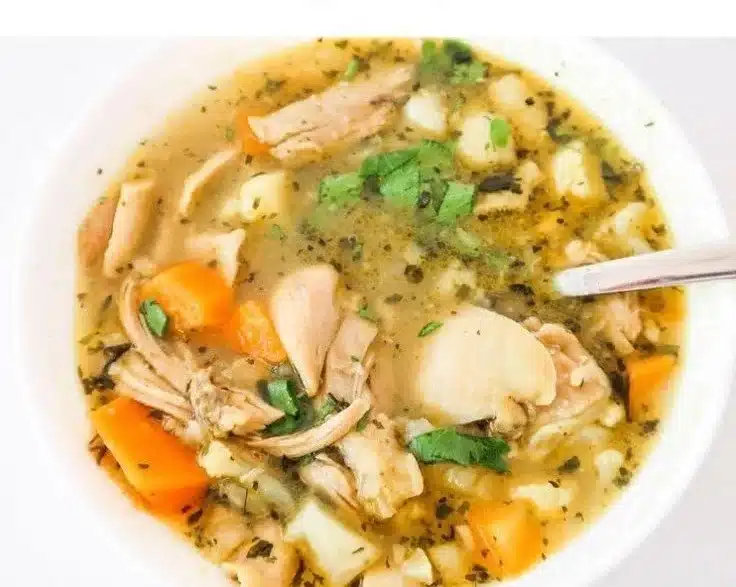 Bowl of anti-inflammatory chicken soup with fresh ingredients.