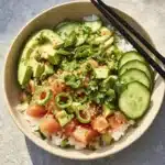 Crispy tofu rice bowl drizzled with Sriracha mayo and garnished with fresh vegetables