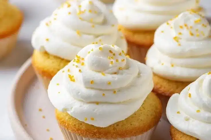 Delicious keto vanilla cupcakes topped with cream frosting.