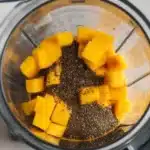 Delicious Mango Chia Seed Smoothie in a glass with fresh ingredients.