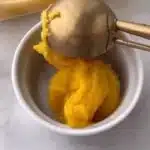 Delicious mango sorbet in a bowl with fresh mango slices on top