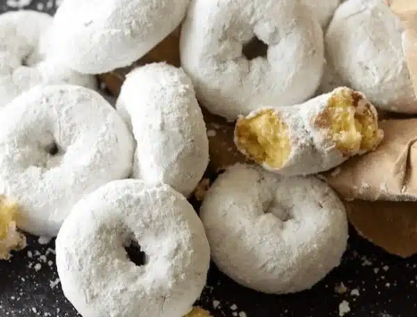 Mini powdered sugar doughnuts dusted with sweet powdered sugar.