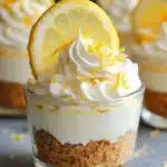 No-bake lemon cheesecake cups topped with fresh lemon zest and berries