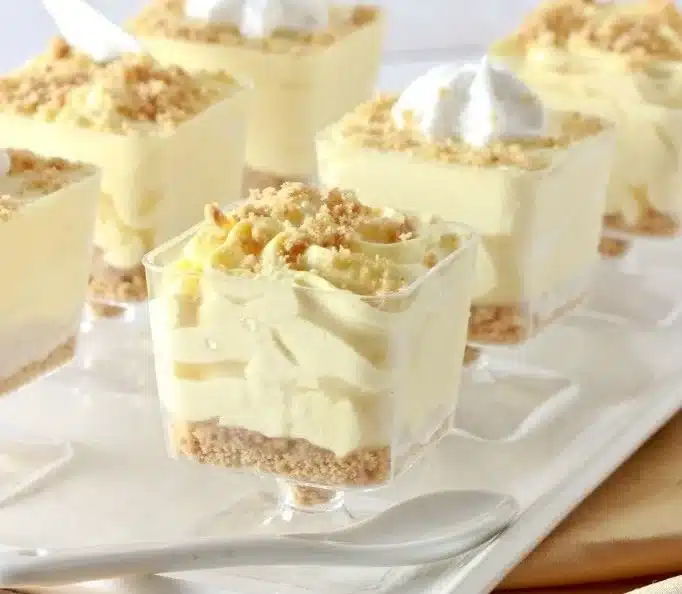 No-bake lemon cheesecake mousse cups topped with lemon zest.