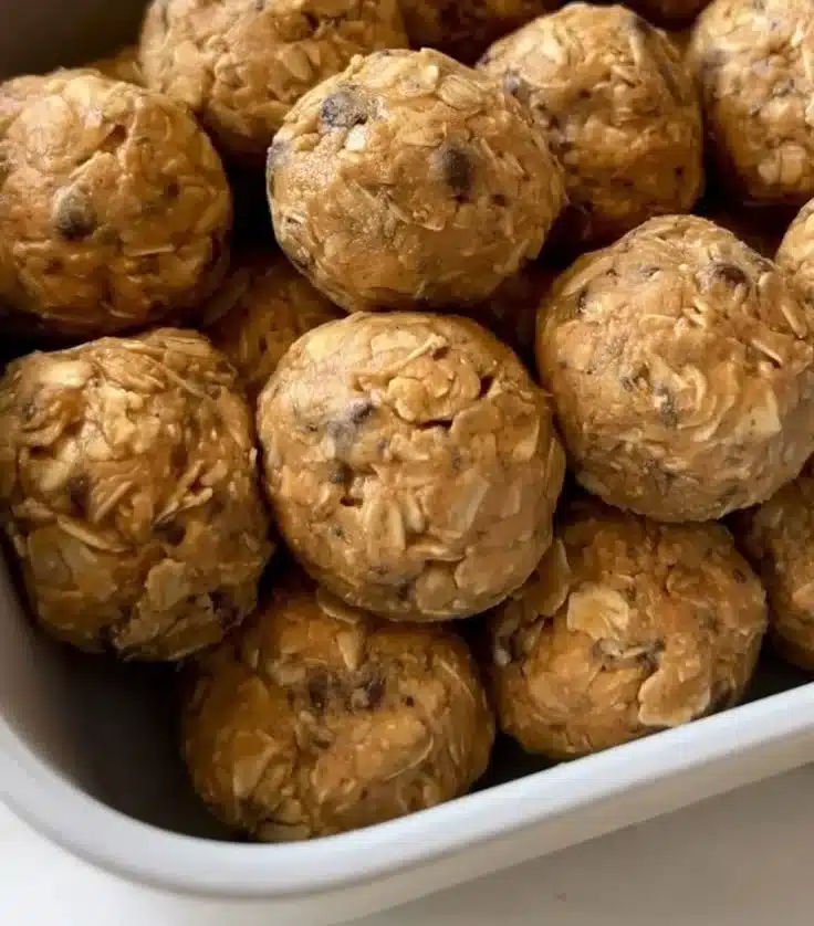 Peanut butter oatmeal balls with chocolate chips on a rustic wooden table.