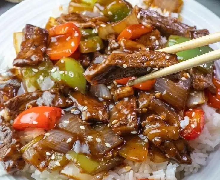 Delicious homemade pepper steak served on a plate with vegetables.