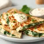 Spinach and Feta Quesadillas served on a plate, garnished with herbs.