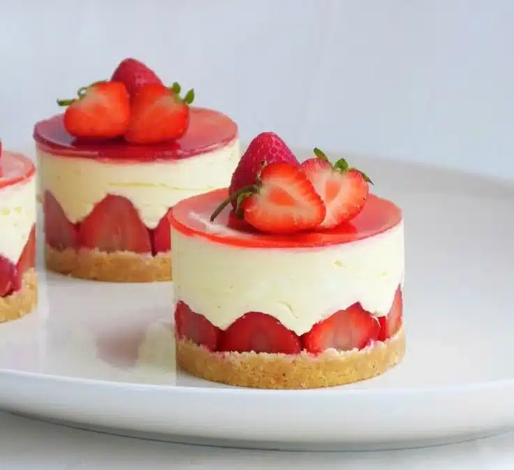 Strawberry and elderflower Fraisier cake adorned with fresh strawberries.