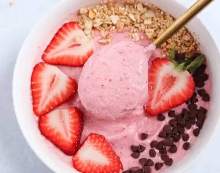 Delicious strawberry Greek yogurt smoothie bowl topped with fresh strawberries