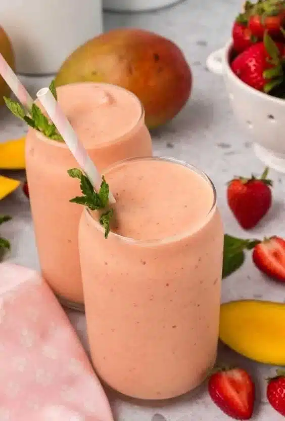 Strawberry mango smoothie in a glass garnished with fresh fruit slices