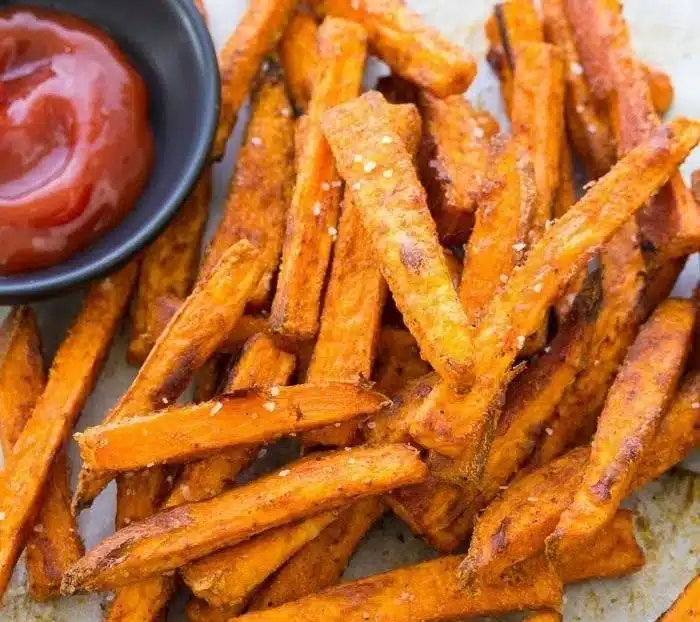 Crispy baked sweet potato fries served in a bowl with dipping sauce