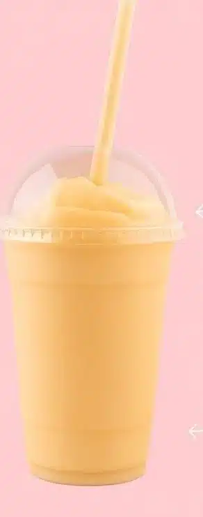 Tropical mango coconut smoothie served in a glass with a straw and garnished with mint.