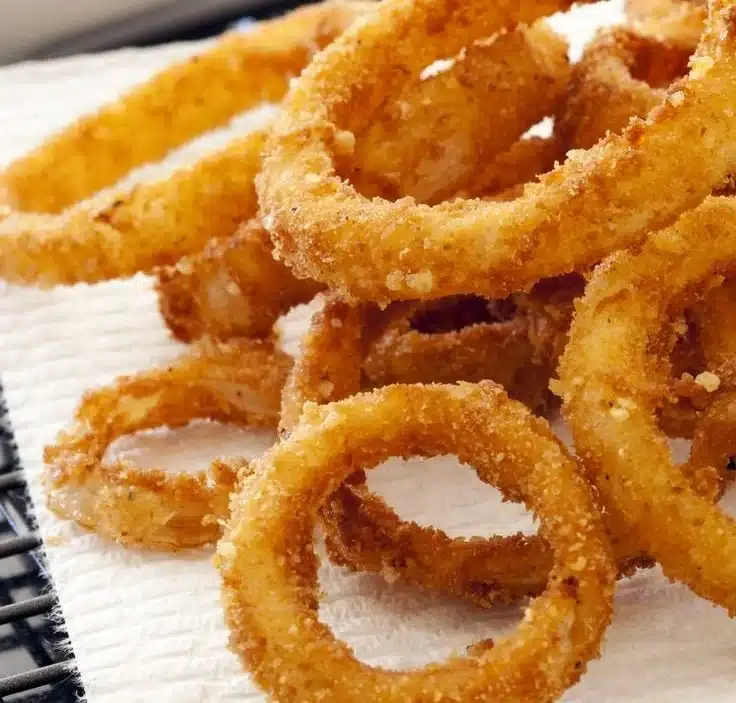Crispy air fryer onion rings served in a bowl with dipping sauce