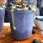 Bowl of blueberry overnight oatmeal topped with fresh blueberries and nuts