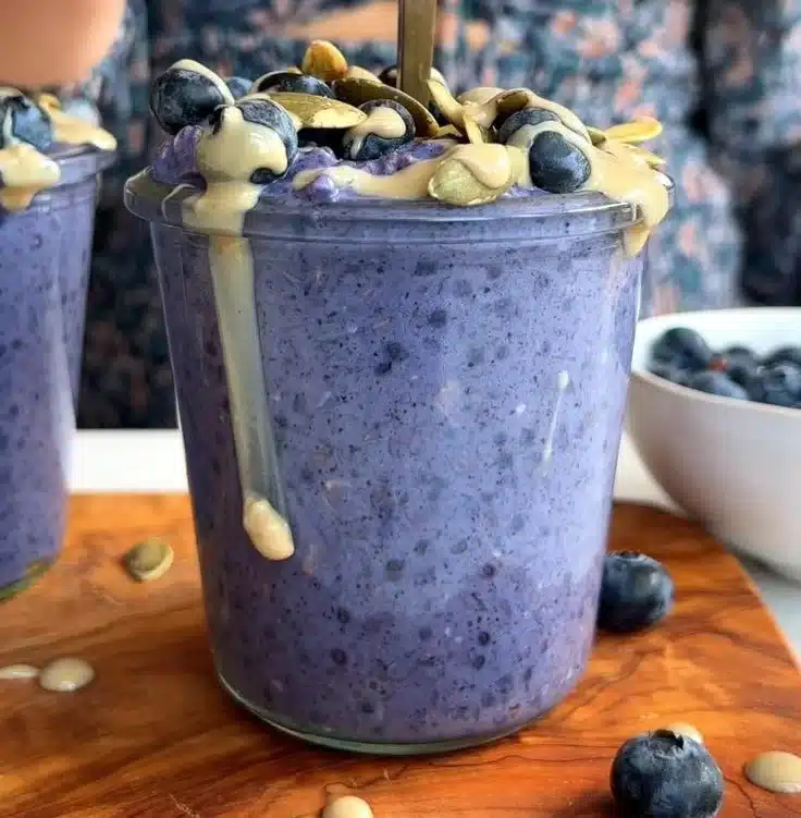 Bowl of blueberry overnight oatmeal topped with fresh blueberries and nuts