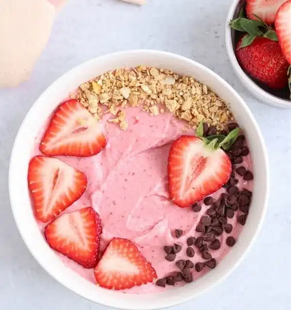 Delicious creamy smoothie bowl topped with fresh fruit and granola