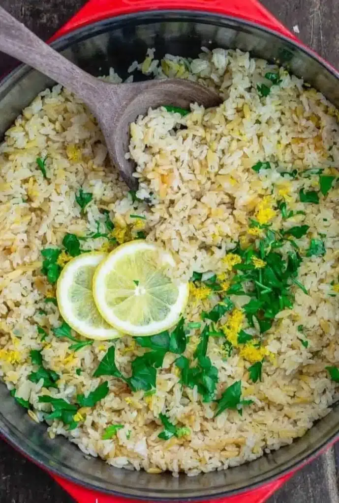 Bowl of Greek Lemon Rice garnished with fresh herbs and lemon slices