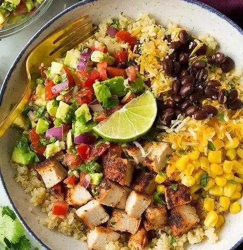 Grilled chicken quinoa burrito bowl with avocado salsa on top