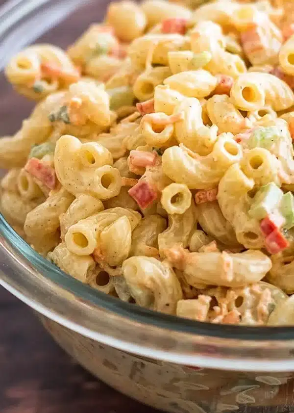 Delicious homemade macaroni salad with colorful vegetables in a bowl