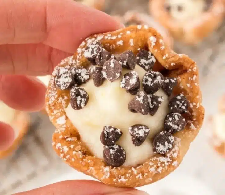 Mini cannoli cups filled with sweet ricotta cream and topped with chocolate chips.