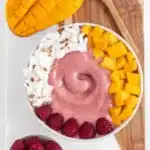 Raspberry Mango Smoothie Bowl topped with fresh fruits and granola