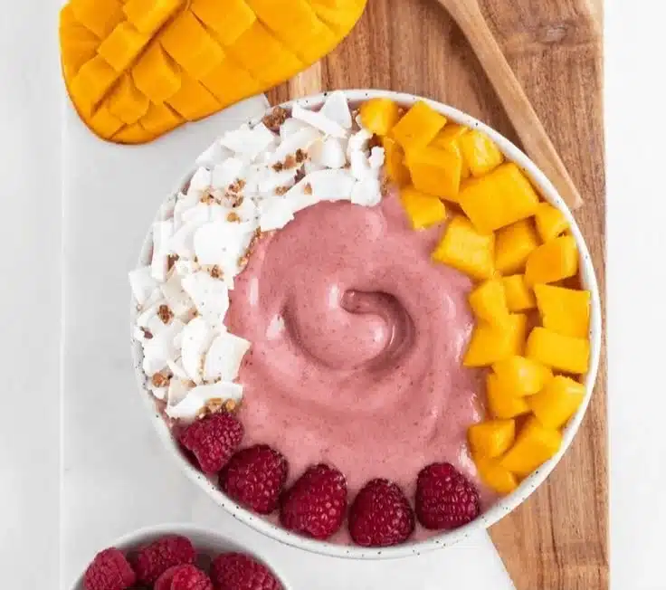 Raspberry Mango Smoothie Bowl topped with fresh fruits and granola