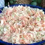 Bowl of simple coleslaw garnished with herbs for a fresh side dish