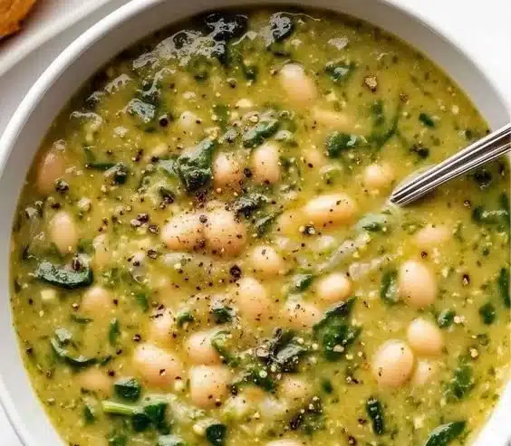 Bowl of delicious Spinach and White Bean Soup garnished with fresh herbs