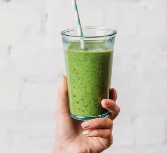 Healthy spinach smoothie with fresh ingredients in a glass