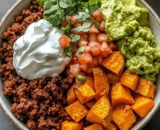 Vibrant sweet potato taco bowl topped with fresh ingredients and served in a bowl