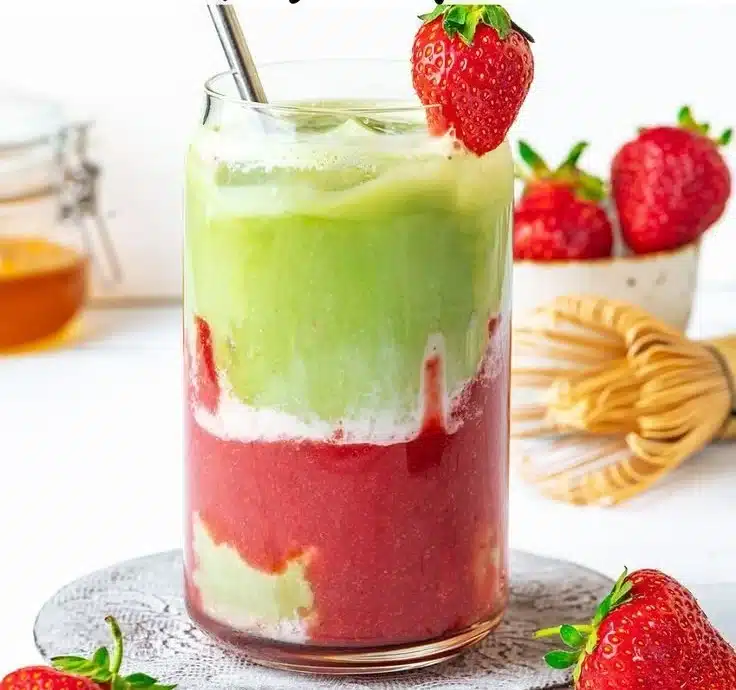Vegan Strawberry Matcha Iced Latte served in a glass with fresh strawberries